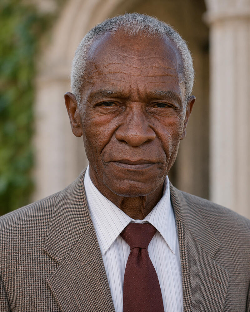 Dr. Hannibal Brown, A Conversation with Dr. Brown Fictional portrait of Dr. Hannibal Brown, an elderly Black professor with short gray hair, wearing a brown suit and burgundy tie.